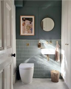 a white toilet sitting under a bathroom mirror next to a wall mounted faucet