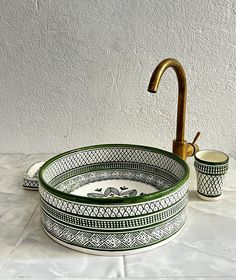 a green and white sink sitting on top of a counter next to a faucet