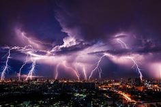 lightning strikes over the city at night time