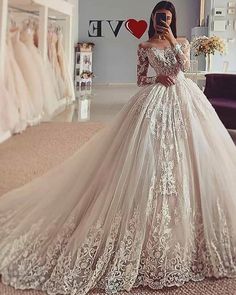 a woman in a wedding dress taking a selfie with her cell phone while standing in front of a mirror