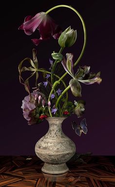 a vase filled with lots of flowers on top of a table