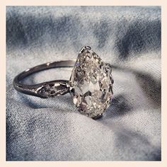 an old cut diamond ring on a blue cloth