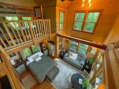 an aerial view of a living room and loft in a log cabin with wood flooring