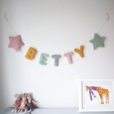 there is a stuffed animal next to the letters that spell it's birth on a string