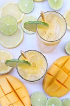 two glasses filled with drinks next to sliced lemons