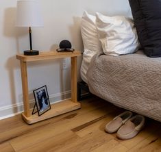 a bedroom with a bed, night stand and lamp on the floor next to it