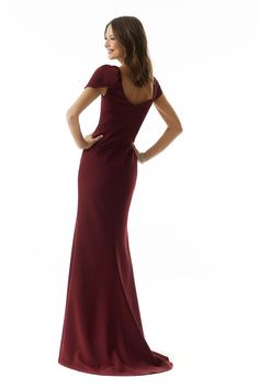 a woman in a long red dress posing for the camera with her hands on her hips