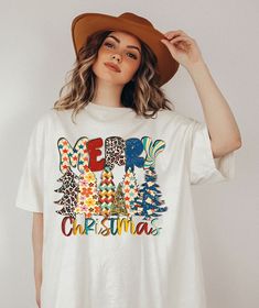 a woman wearing a t - shirt that says merry christmas with an elephant and trees on it