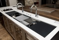 a modern kitchen with an island sink and stainless steel faucets