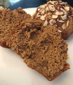 two pieces of cake sitting on top of a white plate next to a muffin