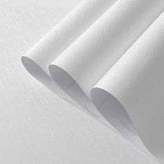 three rolls of white paper sitting on top of each other