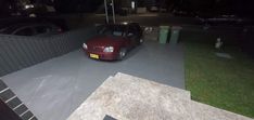 a red car parked in front of a house at night