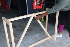 a woman working on a piece of wood with a driller and sawhorse in it