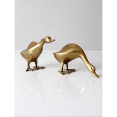 two brass birds are standing next to each other