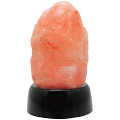 an orange rock sitting on top of a black stand