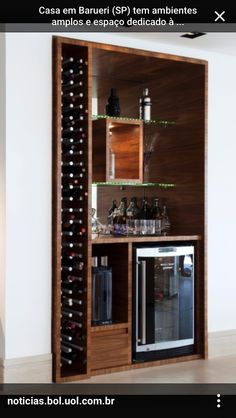 a wine rack in the corner of a room filled with bottles and glasses on it