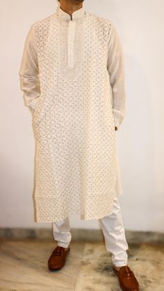 Introducing our Men's Cotton Silk Chikankari Long Kurta, a perfect blend of elegance and comfort.  This exquisite piece features intricate embroidery all over the frontal portion, showcasing the timeless artistry of vintage Chikan shadow French knot stitches. The luxurious cotton silk fabric ensures a smooth and comfortable feel, making it ideal for various occasions.  What sets this kurta apart is its versatility - it can be effortlessly overdyed in any color of your choice, allowing you to personalize your style with ease. Elevate your wardrobe with this fusion of traditional craftsmanship and contemporary design, embodying sophistication in every stitch. In addition we have enhanced the kurta to give it a festive look by adding zari accents throughout the piece. Length - custom length S Traditional Off White Kurta For Transitional Season, Traditional Off-white Kurta With Naqshi, Traditional Off White Kurta With Naqshi, Traditional Cotton Nehru Jacket With Chikankari Embroidery, Formal Traditional Wear With Chikankari Embroidery In Cotton Silk, Classic Cream Kurta For Festive Occasions, Traditional Festive Embroidered Fabric With Tonal Embroidery, Traditional Beige Nehru Jacket With Chikankari Embroidery, Traditional Kurta With Tonal Embroidery For Eid