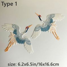 two birds flying next to each other with the words embroidery on it's back