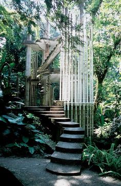 the stairs lead up to an outdoor structure surrounded by trees