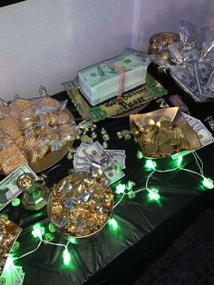 a table topped with lots of gold and green items on top of a black table cloth