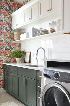 a washer and dryer in a kitchen with floral wallpaper on the walls