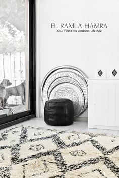 a black and white room with a rug, wall hangings and pictures on the walls