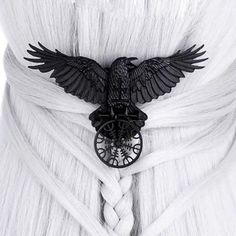 the back of a woman's white dress with an eagle brooch on it