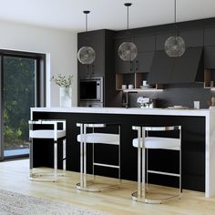 a modern kitchen with black cabinets and white counter tops