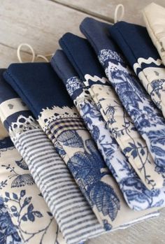 several blue and white napkins are lined up on a table next to each other