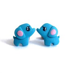 two small blue elephants with pink ears on them'earring backs, facing each other