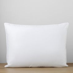 a white pillow sitting on top of a wooden table