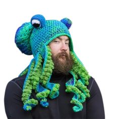 a man wearing a crocheted hat with a green and blue frog on it