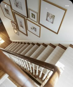 a stair case with pictures on the wall above it