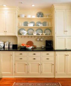 a kitchen with white cabinets and black counter tops