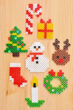 christmas decorations made out of perler beads on a wooden surface with the word merry written in