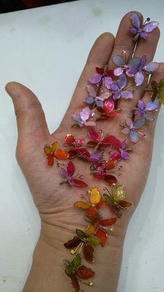 a person's hand with many different colored butterflies on it