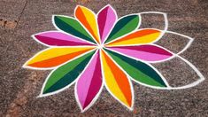 a colorful flower is painted on the ground with white lines and red, yellow, green, orange, and pink colors