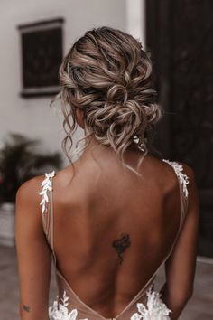 a woman with her back to the camera, wearing a wedding dress and braided hair