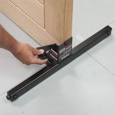 a person is using a stapler to attach a piece of furniture on the floor