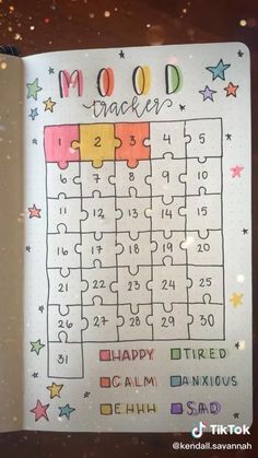 an open notebook with a puzzle on the page and words written in it, mood tracker