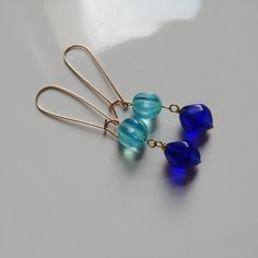 A pair of cobalt blue and aqua glass bead earrings. Made from vintage bohemian Czech glass beads and long gold filled ear wires. They are 2.5" long from the top of the ear wires and 1 cm wide. These are one of a kind and will be shipped in a small jewelry box. Blue Wire-wrapped Glass Earrings, Blue Glass Wire Wrapped Earrings, Blue Wire Wrapped Glass Earrings, Blue Czech Glass Earrings With Faceted Beads, Blue Czech Glass Drop Earrings, Blue Teardrop Czech Glass Jewelry, Blue Czech Glass Teardrop Jewelry, Blue Glass Bohemian Earrings, Bead Dangle Earrings