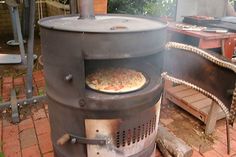 a pizza is being cooked in an outdoor wood fired oven on brick patio area with chairs and tables