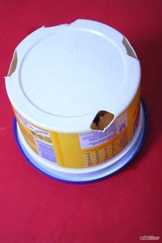 a white container with yellow lid sitting on top of a red table