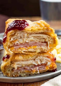 two ham and cheese pastries stacked on top of each other with jam in the middle