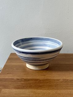 a blue and white bowl sitting on top of a wooden table