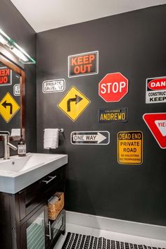 a bathroom with several signs on the wall and a sink in front of it that says keep out