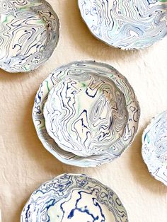 four blue and white plates sitting on top of a table