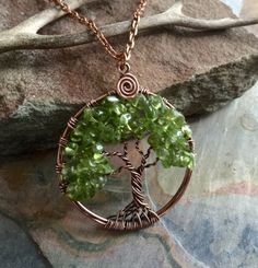 Peridot is a beautiful August Birthstone! Handmade this unique & gorgeous wire wrapped Tree of Life pendant necklace is made with genuine Peridot gemstone using natural copper wires. The pendant has been antiqued, hammered & forged to give strength & texture to bring out the stunning details of the finished pendant. The pendant measures between 1.40 to 1.45 inch in diameter. It comes with an antiqued copper finished chain. Each pendant is handmade, so please allow slight variations f Wire Wrapped Necklaces As May Birthstone Gift, Nature-inspired Wire Wrapped Crystal Pendant Necklaces, Green Copper Hand Wrapped Necklaces, Green Hand Wrapped Copper Necklace, Wire Wrapped Pendant Necklaces For May Birthstone, Green Peridot Wire Wrapped Jewelry, Green Copper Round Pendant Jewelry, Handmade Peridot Jewelry For May Birthstone, Green Hand Wrapped Crystal Necklace Gift