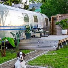 a dog sitting in front of a trailer