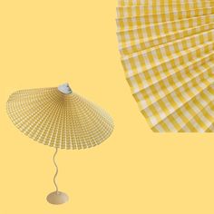 a yellow and white checkered umbrella next to a small lamp on a light yellow background